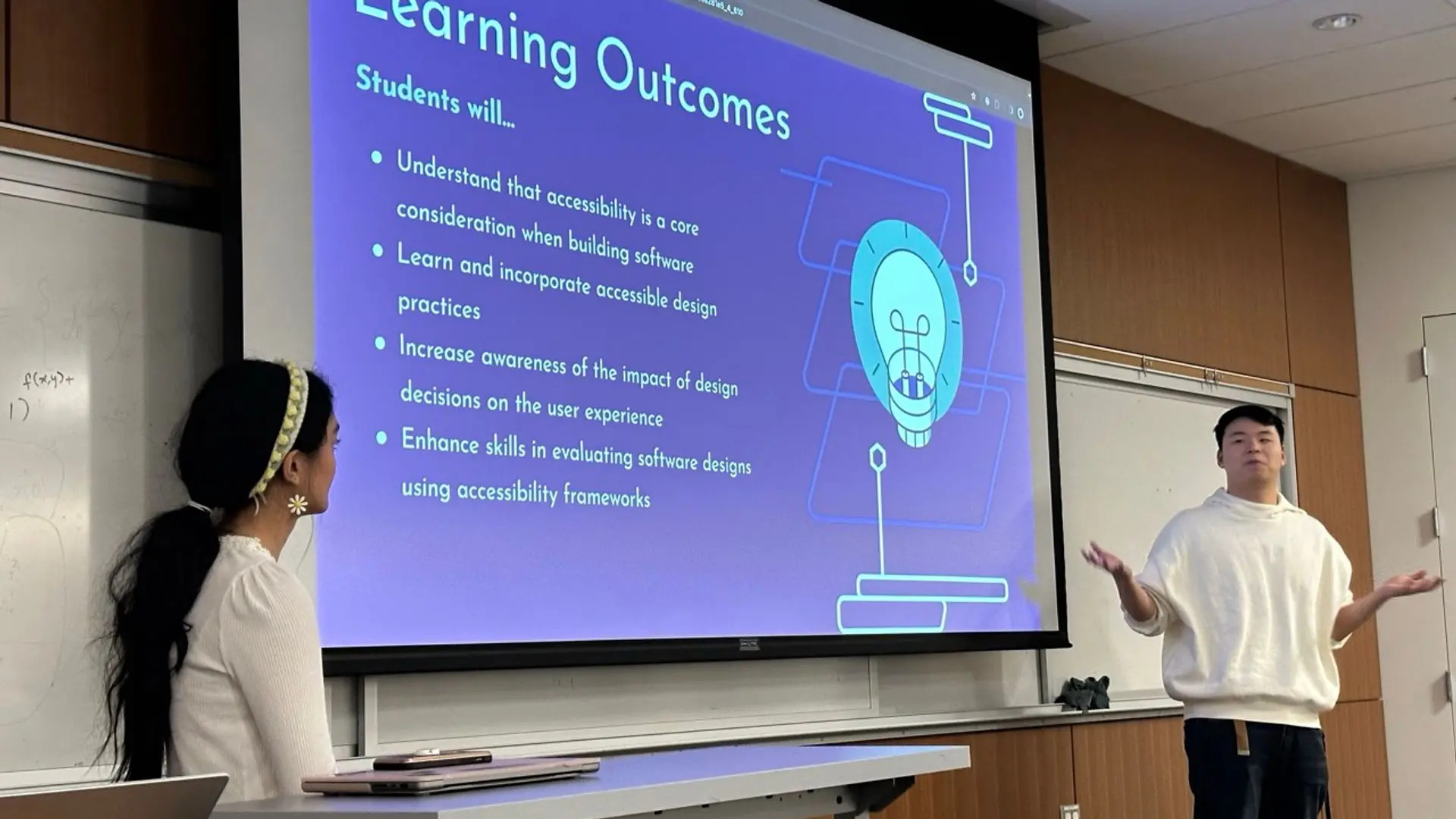 Two presenters in the midst of discussing their research