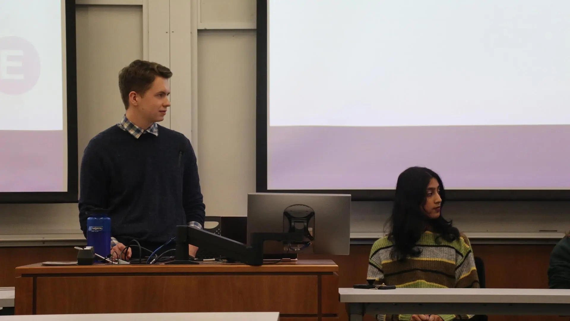 A TA and the moderator looking over at the TA that is talking outside of the image