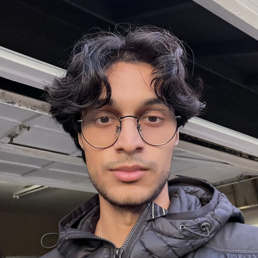 Arpan Kapoor smiling in front of an open garage door.