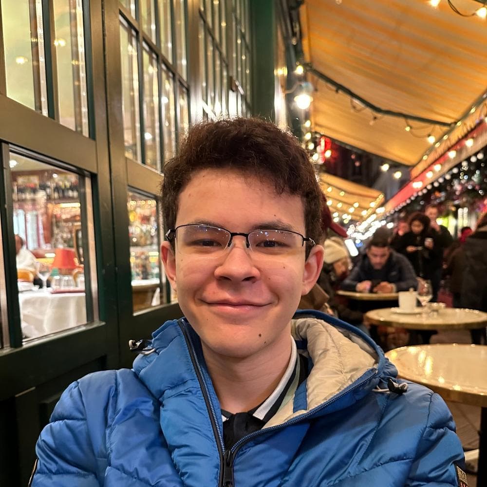 Benoit Le smiling while sitting indoors.