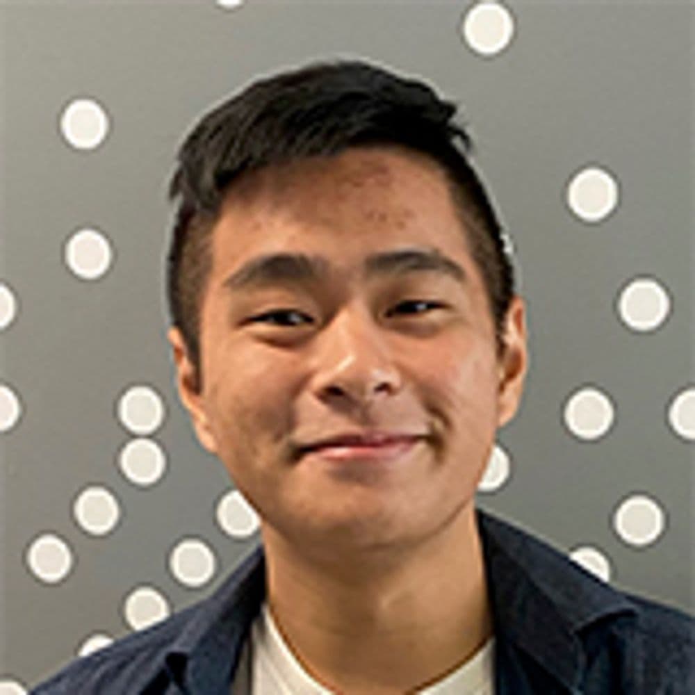 Matt Wang smiling in front of a polka dotted wall.